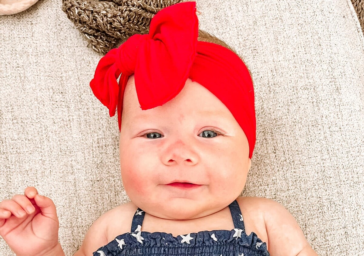 A happy baby wearing a red bandana